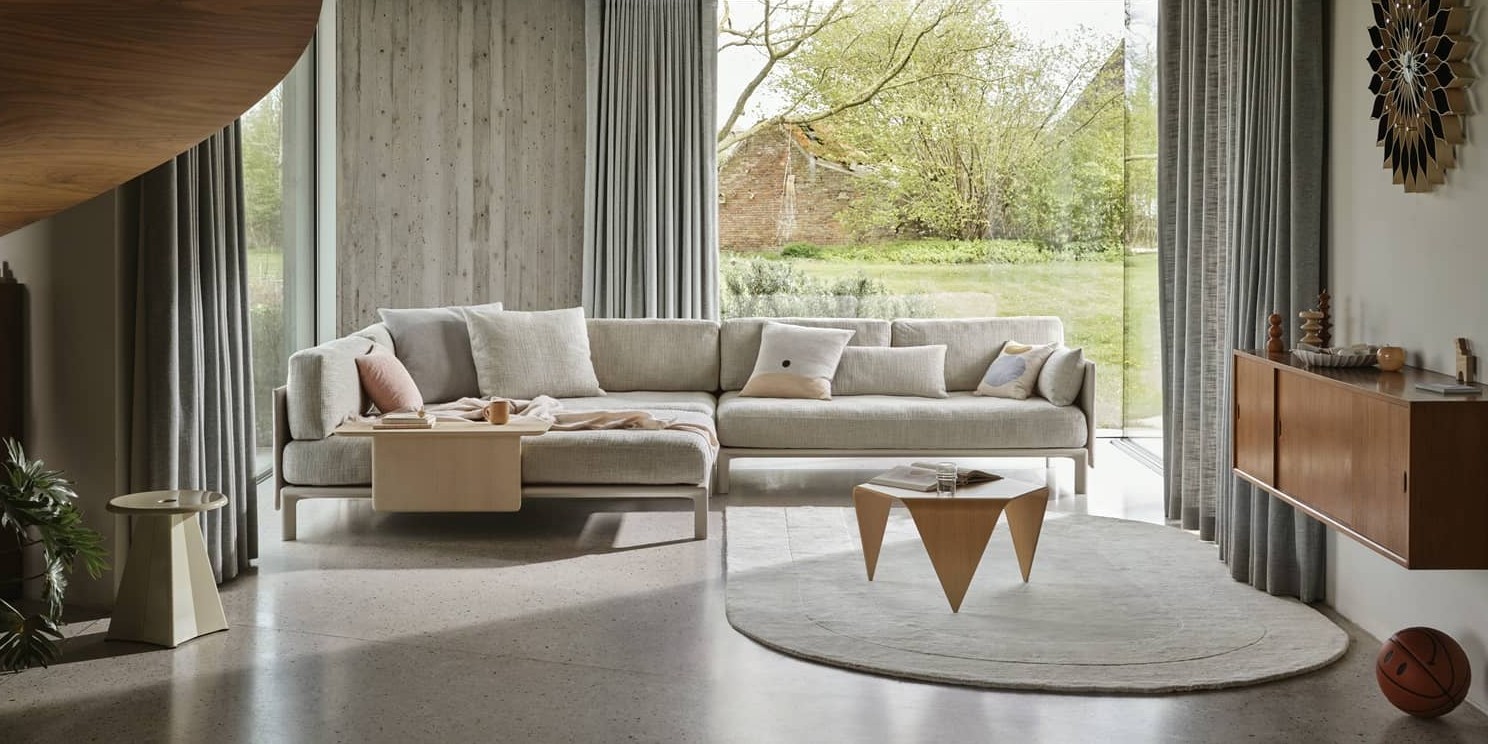 Ein grosses, stilvoll eingerichtetes Wohnzimmer mit grossem Sofa und weichem Teppich